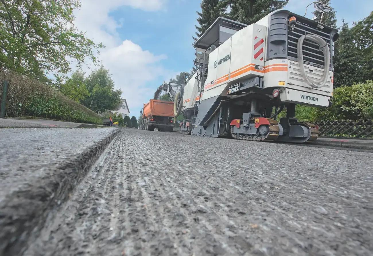 Wirtgen W 210 фрезерует дорожное покрытие с погрузкой материала в самосвал